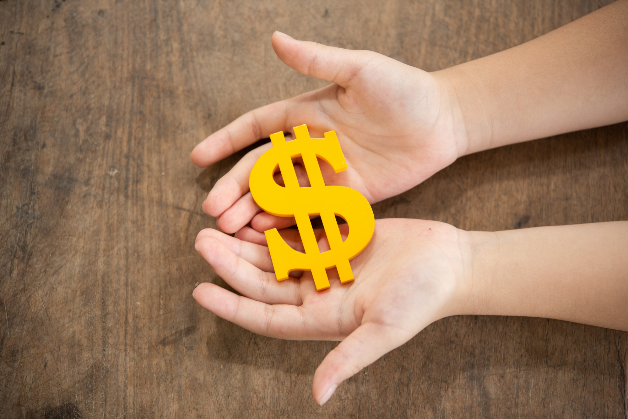 child-holding-yellow-dollar-sign