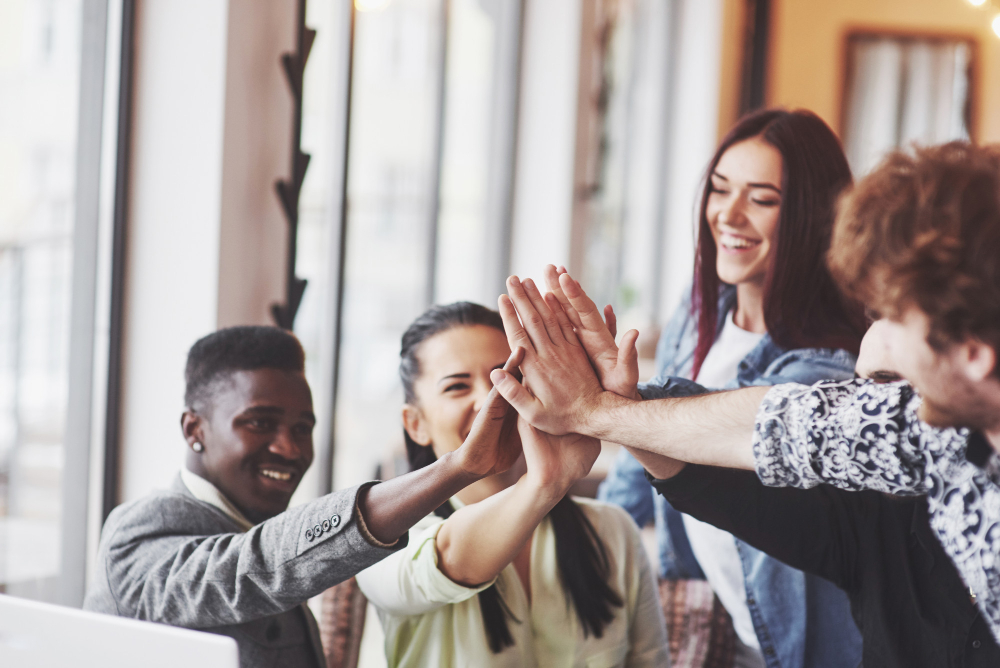 happy-young-entrepreneurs-casual-clothes-cafe-table-business-office-giving-high-fives-each-other-as-if-celebrating-success-starting-new-project